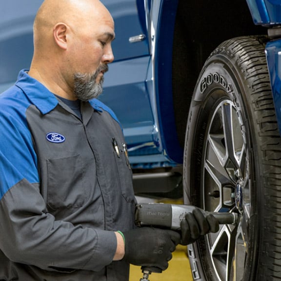  Ford Service Tech with Car Tire | Inverness, FL